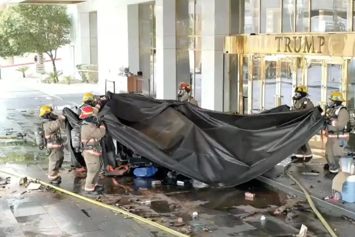 A screen grab from a police video shows firefighters removing a tarpaulin after  extinguishing a Tesla Cybertruck that exploded in front of the Trump Hotel in Las Vegas, on Jan 1.