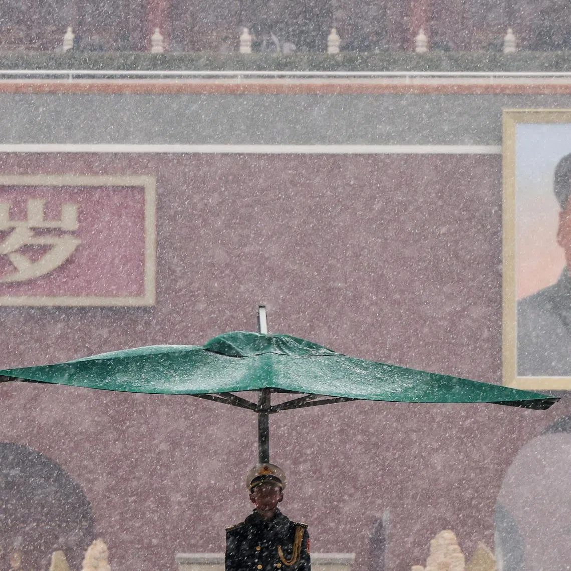 A People’s Liberation Army honor guard stands under an umbrella during heavy snowfall, with the Tiananmen Gate featuring a portrait of late Chinese Chairman Mao Zedong in the background, in Beijing, China, March 4, 2026. REUTERS/Maxim Shemetov/File Photo