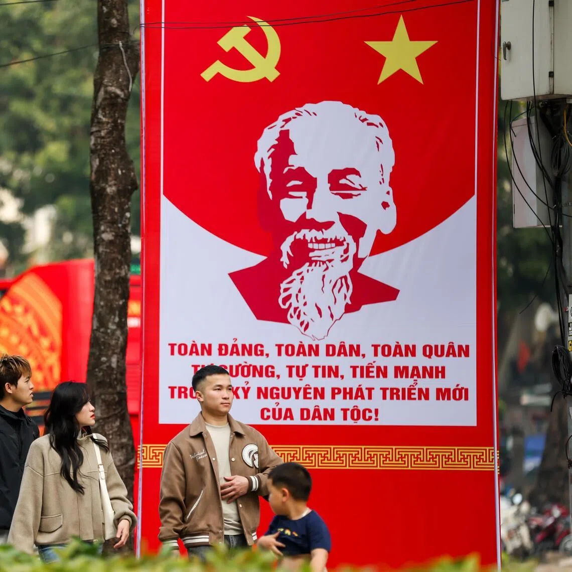 epa12644129 People walk past a signage for the upcoming 14th National Congress of the Communist Party of Vietnam, in Hanoi, Vietnam, 12 January 2026. The Congress is scheduled for 19-25 January 2026.  EPA/LUONG THAI LINH