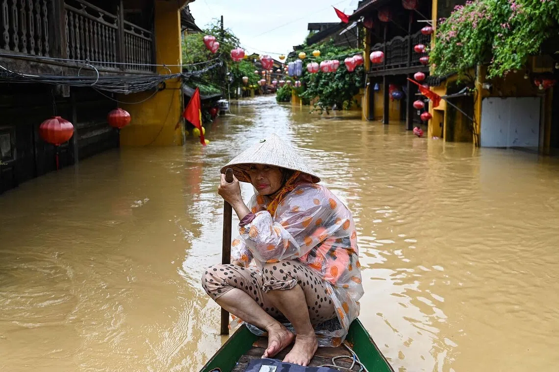 A woman rowing a boat on a flooded street following heavy rains in Hoi An on Oct 30, 2025. 