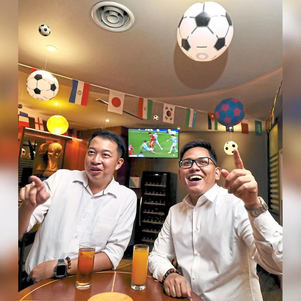 Football fans Chan Kok Leong (left) and Visshan Miyanathan watch a match at the lounge of Concorde Hotel Kuala Lumpur.
