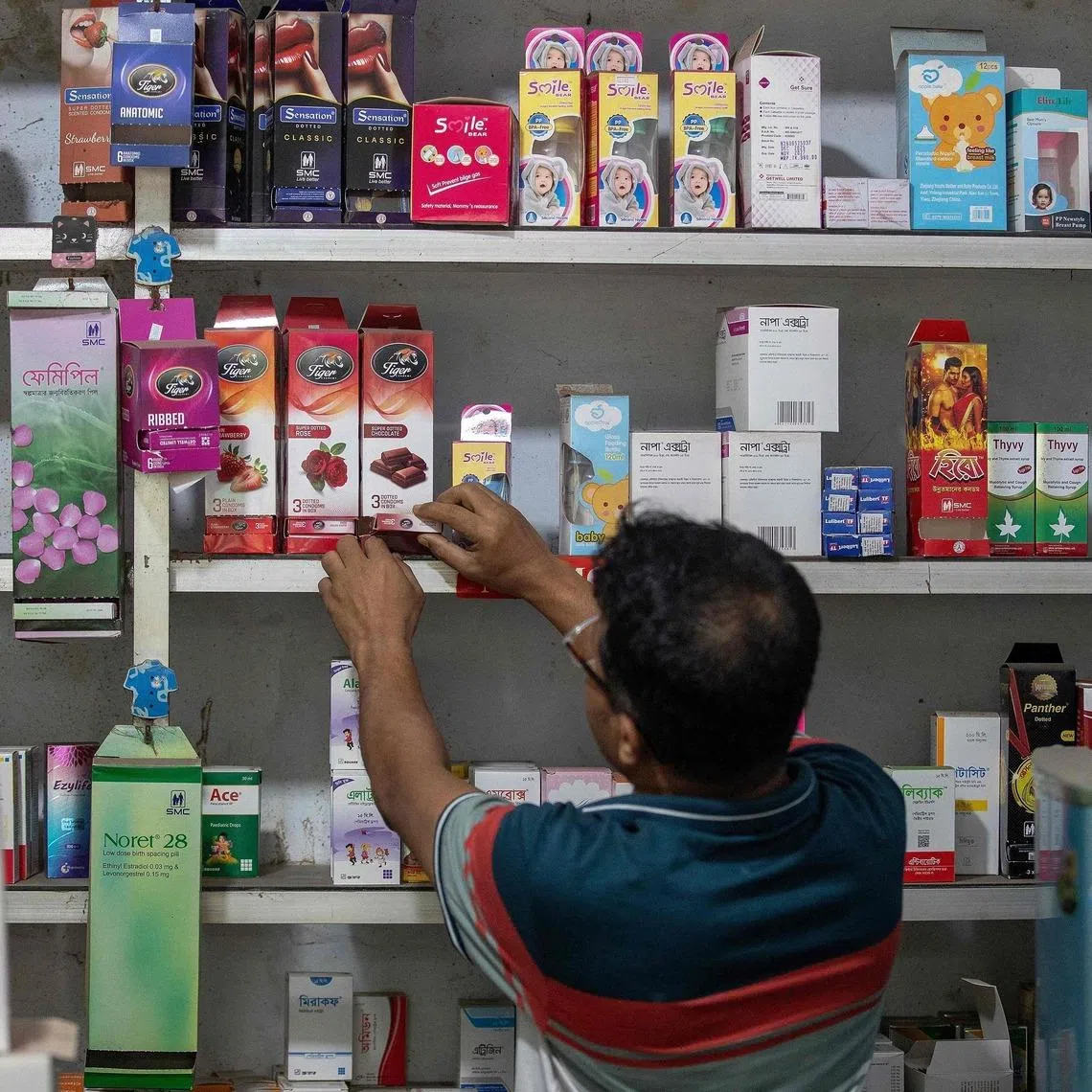 A worker arranging packets of condoms at a pharmacy in Dhaka, Bangladesh, on April 27. Government clinics across the country of 170 million people running out of basic contraceptives.