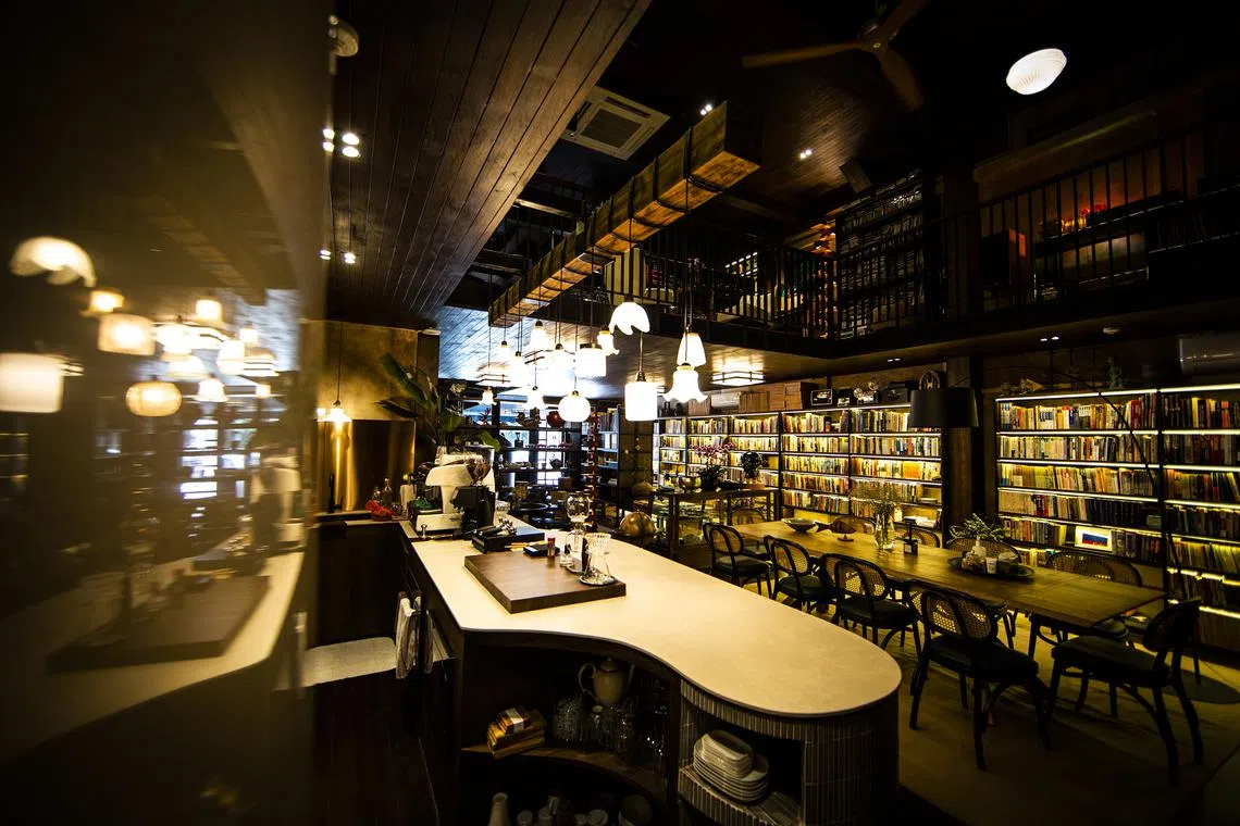 asguru - The office of Ms Lim Sau Hoong and Mr Wayne Peng has a meeting area which is serviced by a fully functional kitchen. Timber is a main feature in the design which adds to the warm tones cast by a row of pendant lights that were bought second hand hanging over the kitchen counter. PHOTO: WAYNE PENG