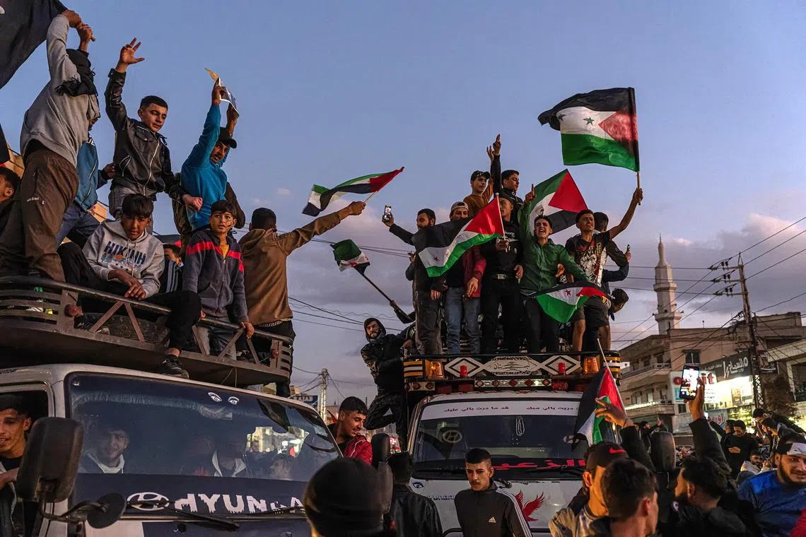 Hundreds celebrate the end of President Bashar al-Assad's long and brutal grip on Syria on a road leading to the border between Lebanon and Syria on Dec 8.