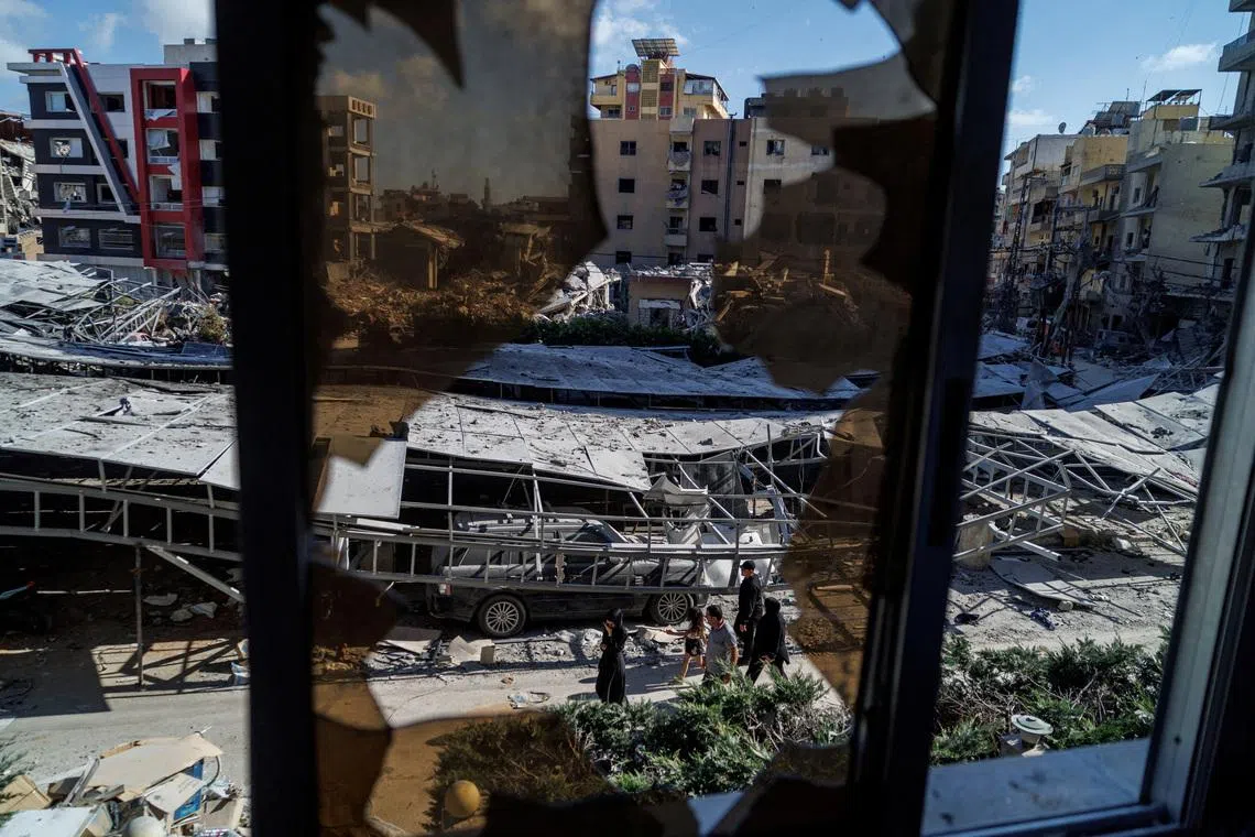 People walking past rubble at the site of an Israeli strike, following a deal between the US and Iran in Tyre, southern Lebanon, June 16, 2026. 