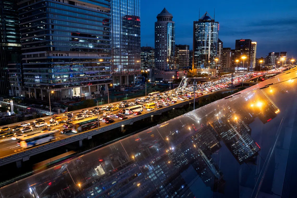 Cars are stuck in traffic on an elevated highway as buildings are reflected on a glass surface in Beijing's central business district (CBD), China, November 12, 2025. REUTERS/Maxim Shemetov