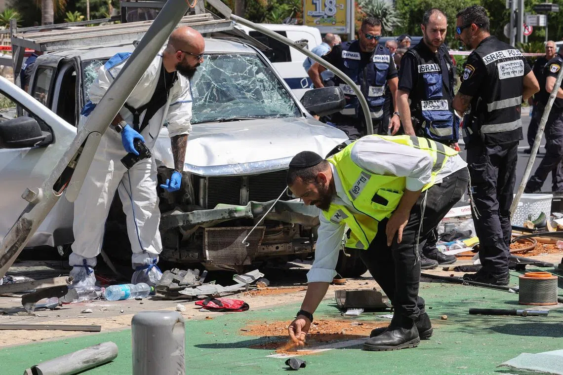 Israeli security and emergency personnel working at the site of a reported car ramming attack in Tel Aviv on July 4, 2023.