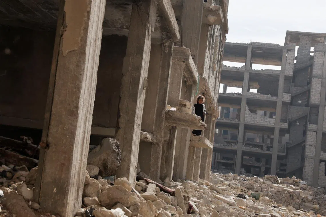 A girl looks from a damaged building in Tadamon district, which is littered with bones after what residents and rights groups described as years of killings there under the rule of Syria's Bashar al-Assad, following al-Assad's ousting by fighters of the ruling Syrian body, in Damascus, Syria, December 12, 2024. REUTERS/Amr Abdallah Dalsh
