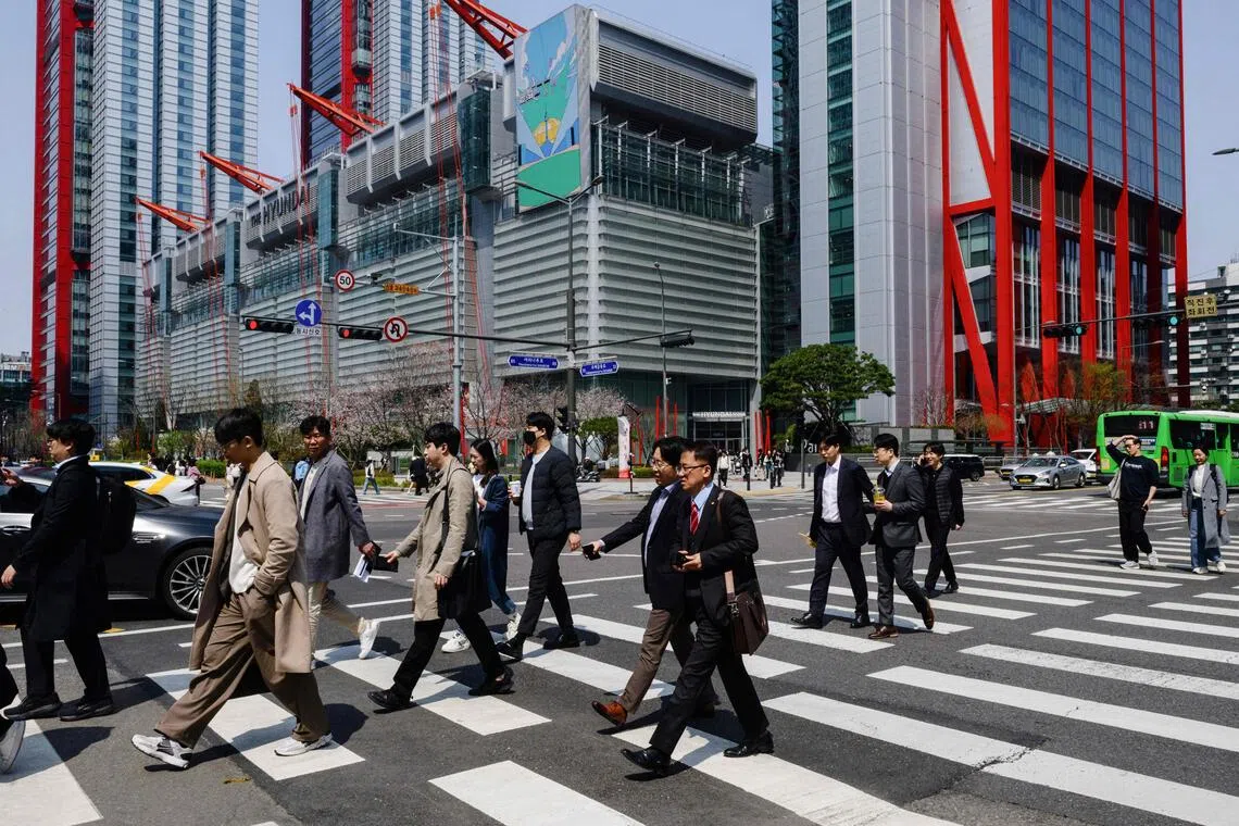 Pedestrians walk across a road in Seoul on Apr 7, 2025. 