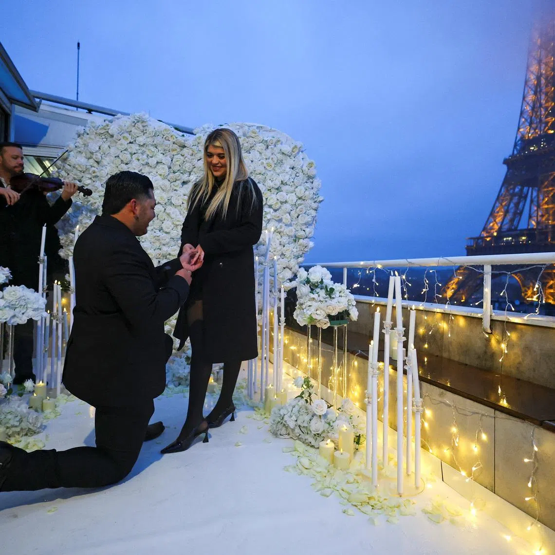 Josue Perales from Texas proposes to his girlfriend Kayla Balboa during an event organised by proposal‑planning agency 'Les Entremetteuses' on a private terrace near the Eiffel Tower in Paris, France, February 10, 2026. REUTERS/Sarah Meyssonnier