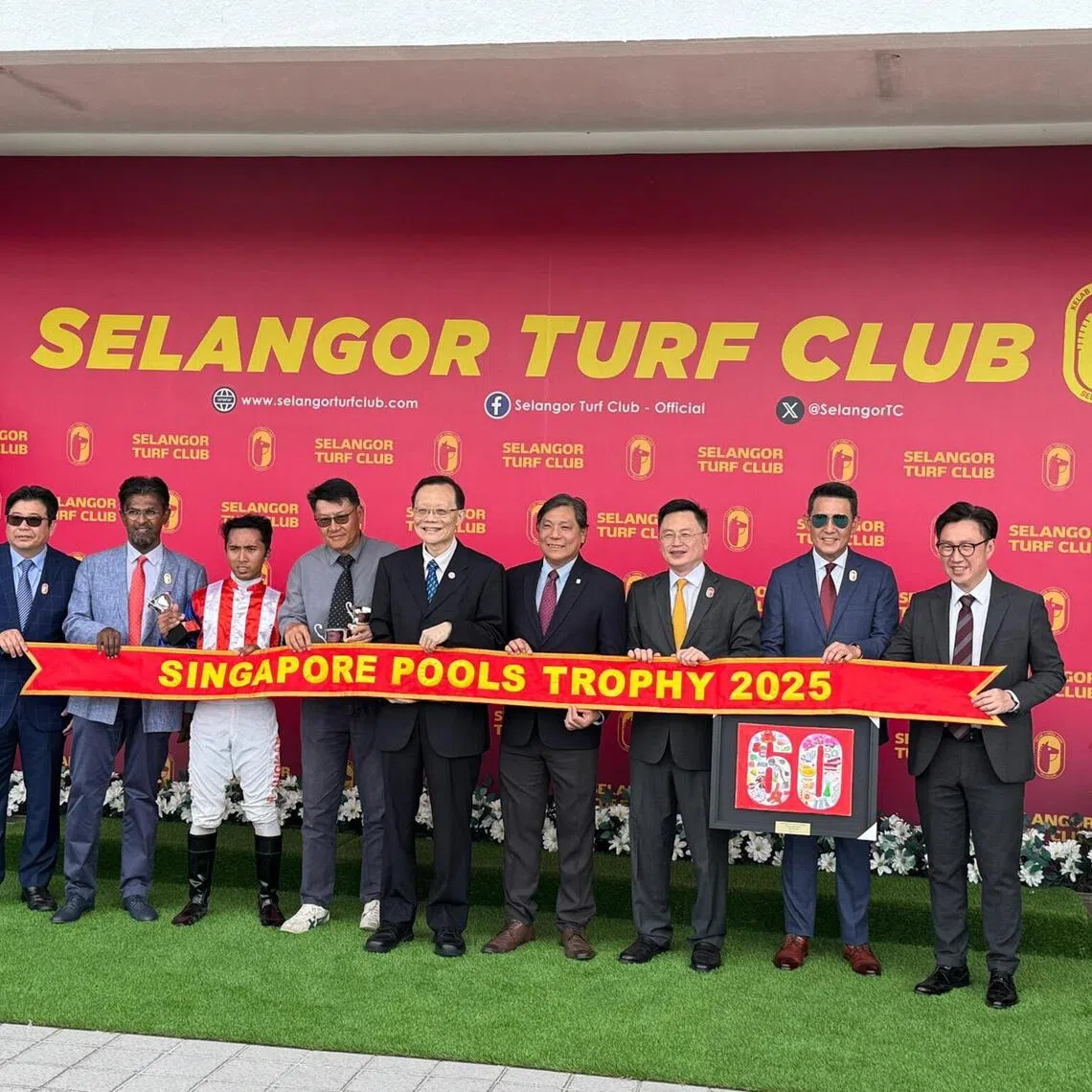 mmpools08 - Singapore Pools chief product officer  Simon Leong (fourth from right) and board member Tan Choon Shian (fifth from right) sharing the stage with winning trainer Jerome Tan (grey shirt) and jockey Nuqman Rozi at the prize presentation following Big Union's win in the Singapore Pools Trophy (1,200m) at Sungai Besi on Dec 7. Also on hand are Selangor Turf Club deputy chairman Clement Chew (third from right), CEO Michael Fong (right), and committee members Goik Kenzu (left), Mahendran Ponnah (second from left) and Rodney Cheah (second from right).

Photo by Singapore Pools