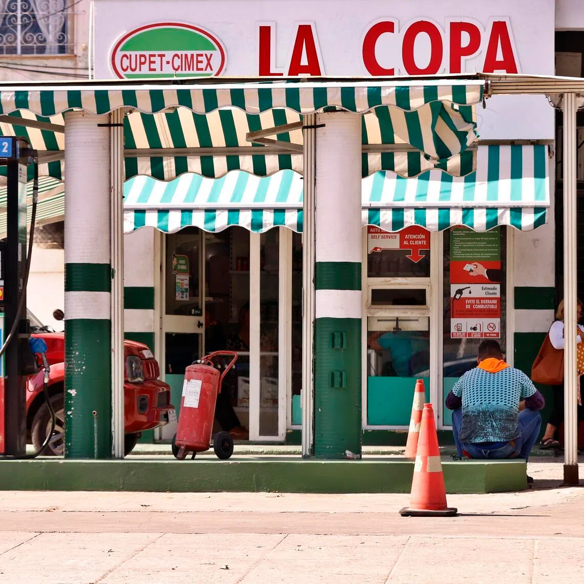 A person sits at a gas station in Havana on Feb 9. The country is facing a shortage of jet fuel, highlighting the severe impact of US energy restrictions on an island already grappling with a serious economic crisis.  