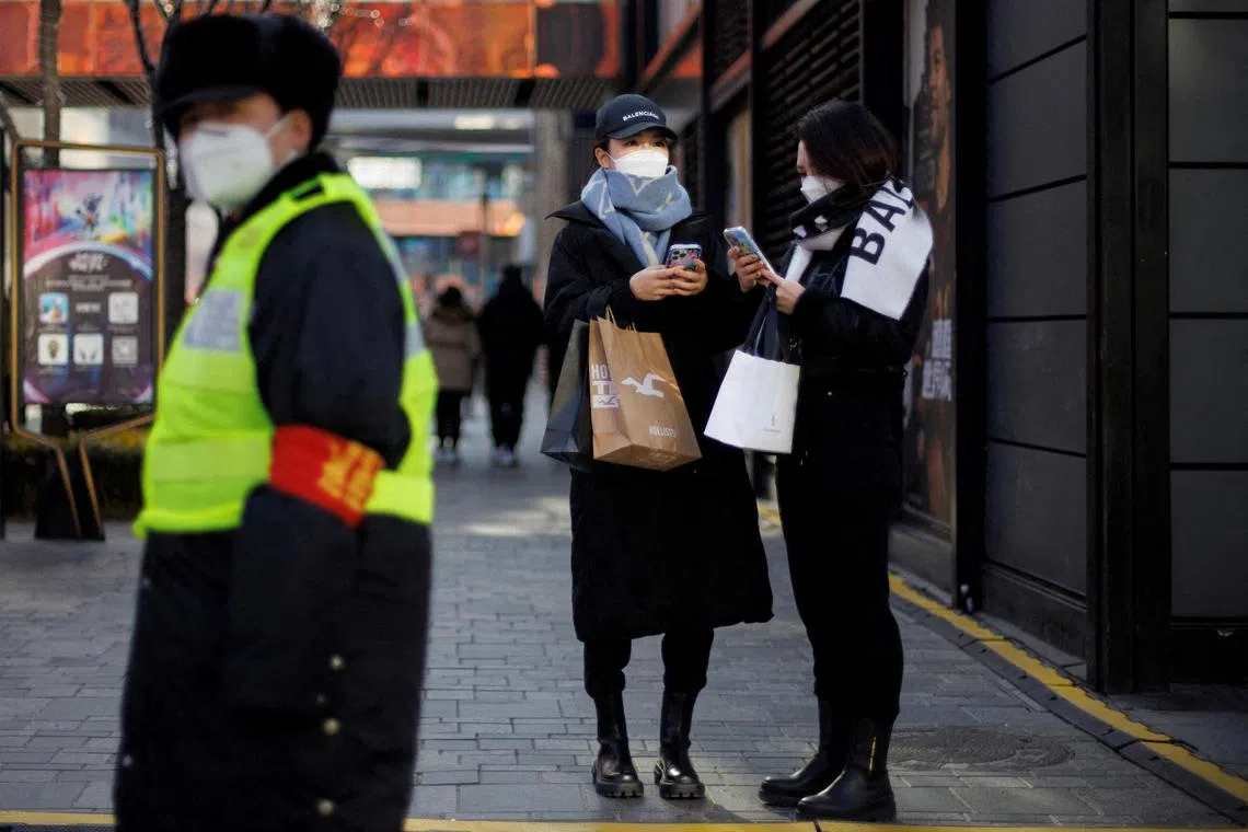 Women with shopping bags standing in a street in Beijing as China returns to work despite continuing Covid-19 cases, on Jan 3, 2023.