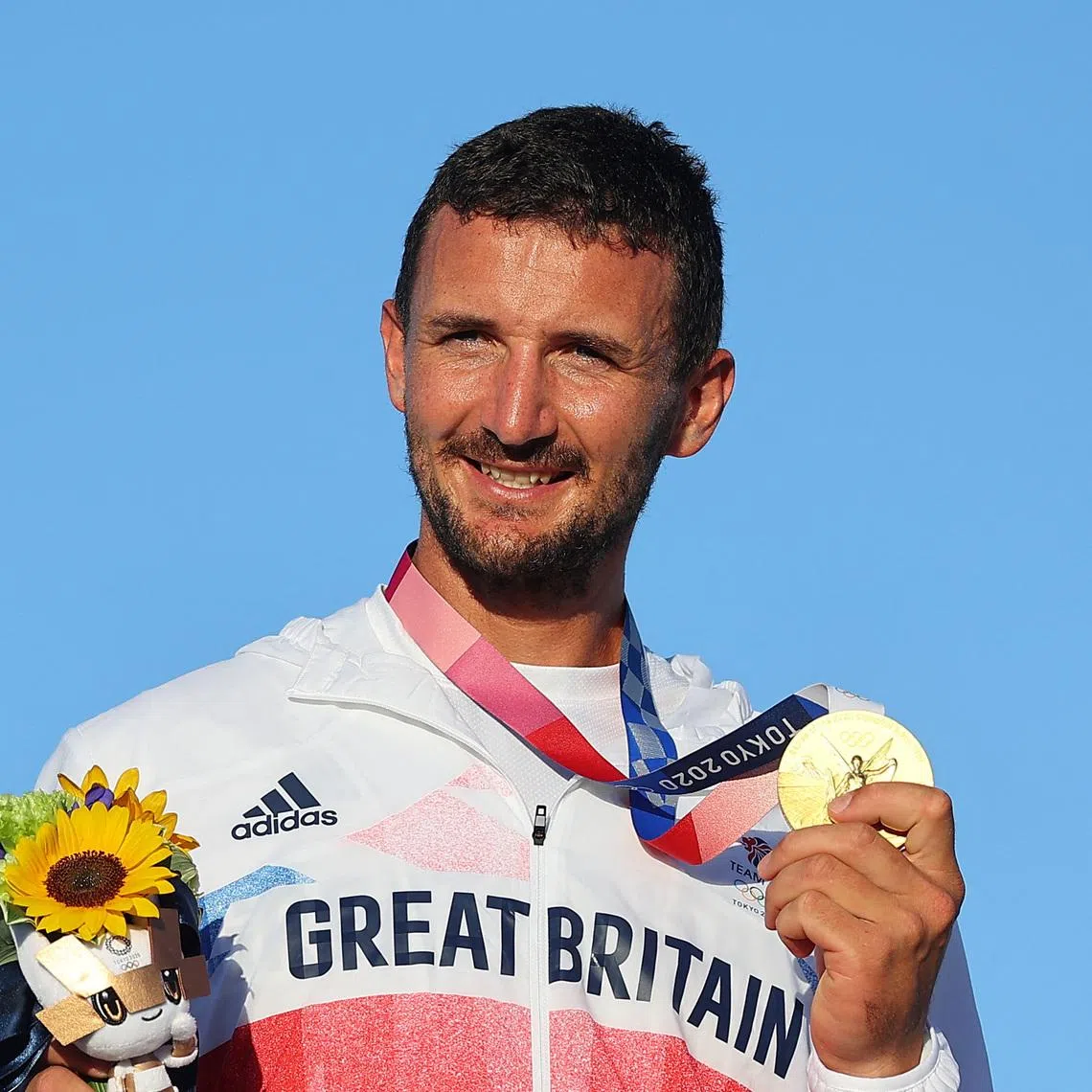 FILE PHOTO: Tokyo 2020 Olympics - Sailing - Men's Finn - Medal Ceremony - Enoshima Yacht Harbour - Tokyo, Japan - August 3, 2021. Gold medallist Giles Scott of Britain celebrates on the podium. REUTERS/Carlos Barria/File Photo