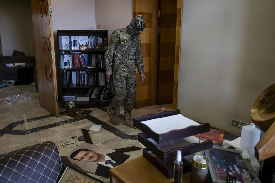 Abu Oweis, a rebel fighter, in the office of a longtime senior adviser to Bashar al-Assad at the abandoned presidential palace in Damascus, Syria, Dec. 10, 2024. President Bashar Assad, who wielded fear and force over Syria for more than two decades, fled the country under the cover of night Ñ and a fake political address. (Nicole Tung/The New York Times)