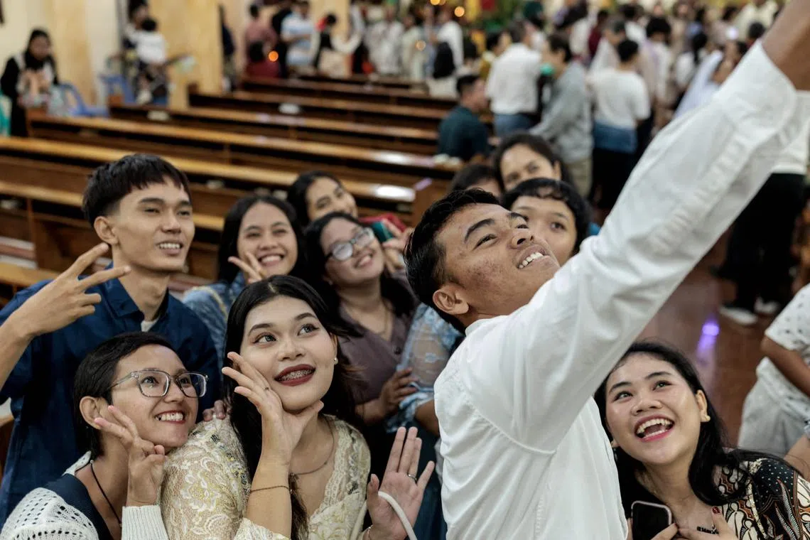 Catholics take selfies after the Christmas Eve Mass at the Sacred Heart Catholic Church in Banda Aceh on Dec 24.