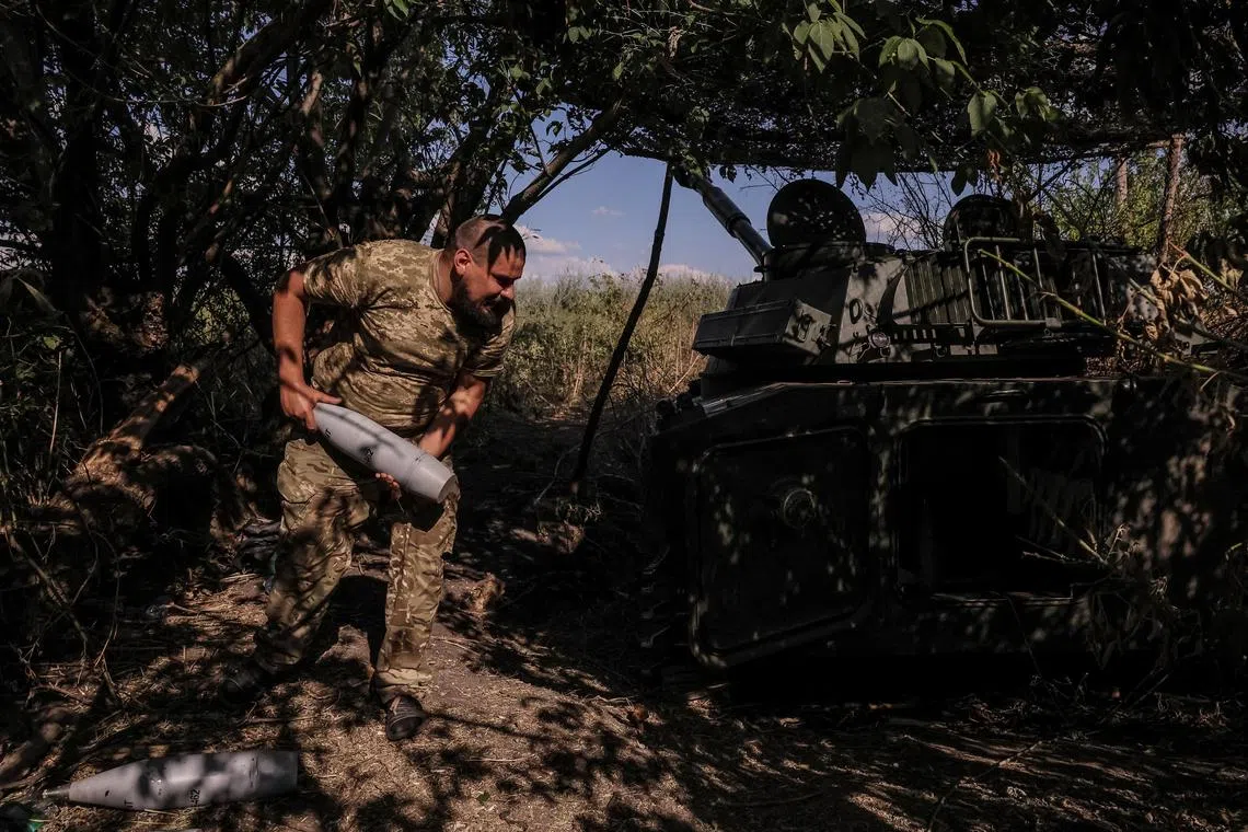 A Ukrainian serviceman loads a shell into a self-propelled howitzer, near the town of Chasiv Yar, in Ukraine's Donetsk region.