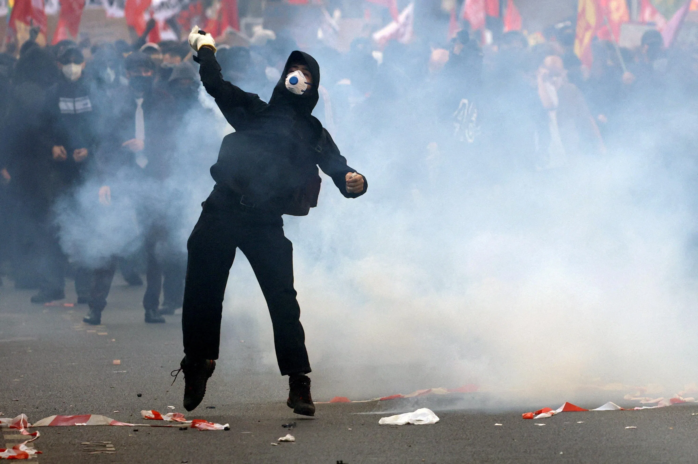 A masked protester throwing an object, amid clashes with French police in Paris on Oct 6.