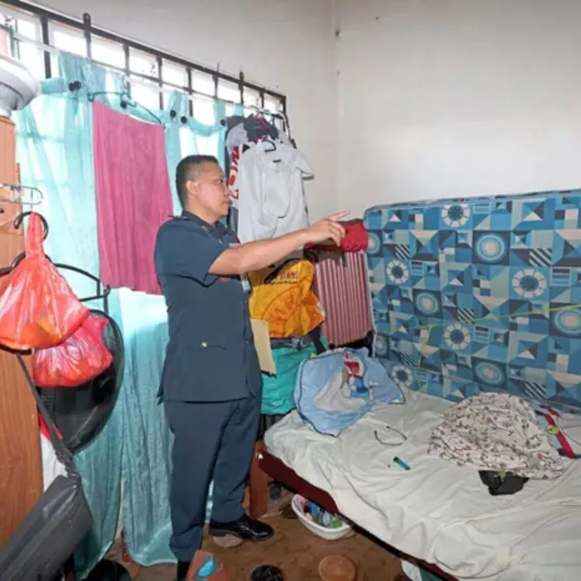 A Malaysian Fire and Rescue Department officer inspecting one of the rooms of a modified shophouse.
