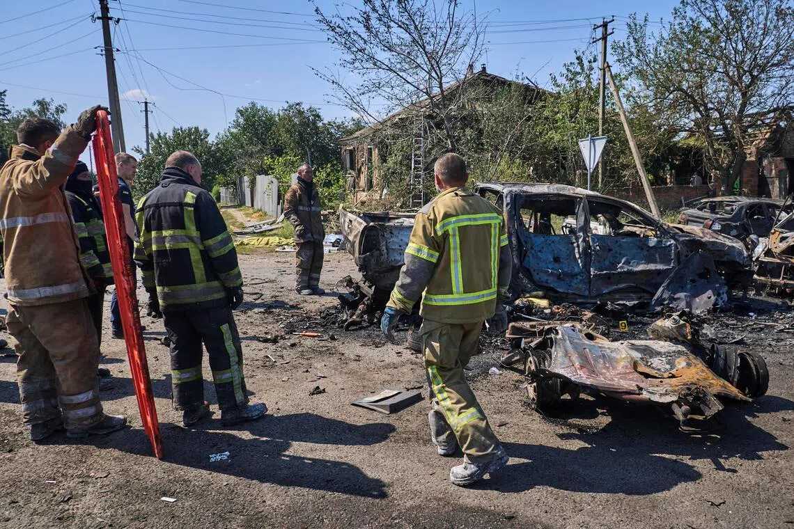 Ukrainian rescuers working at the site of a Russian missile strike in the village of Pechenihy, in Ukraine’s Kharkiv region, on Aug 18.