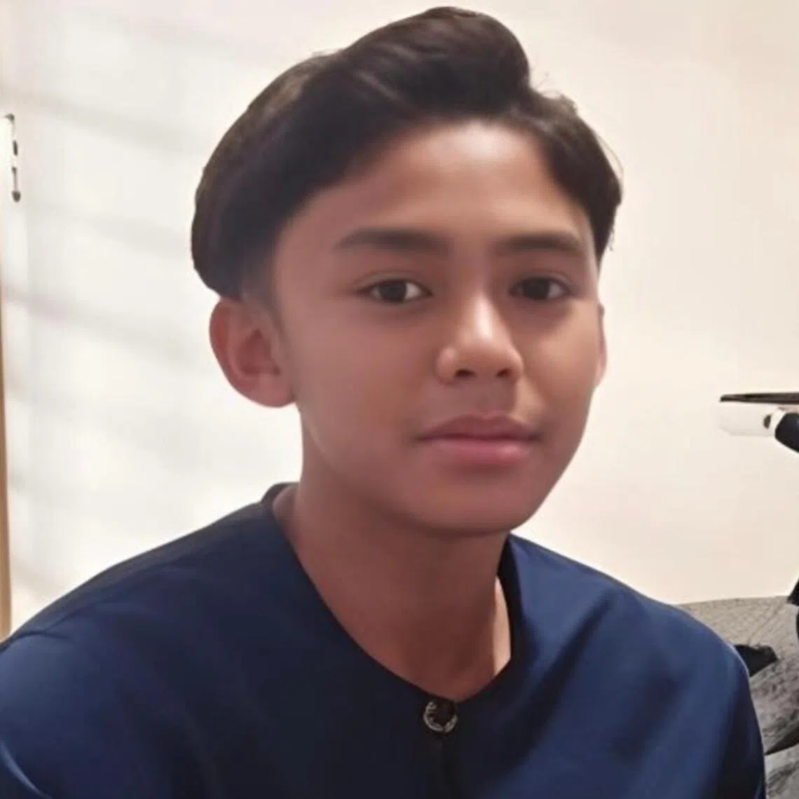 He was wearing his school uniform with a white short-sleeved shirt and dark blue trousers.