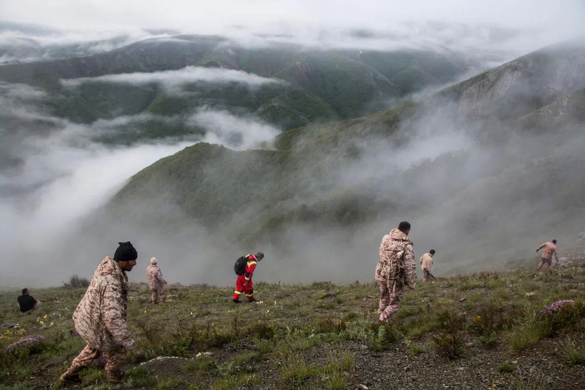 Rescue team members searching an area near the crash site of a helicopter carrying Iranian President Ebrahim Raisi in Varzaghan, in northwestern Iran, on May 20, 2024.