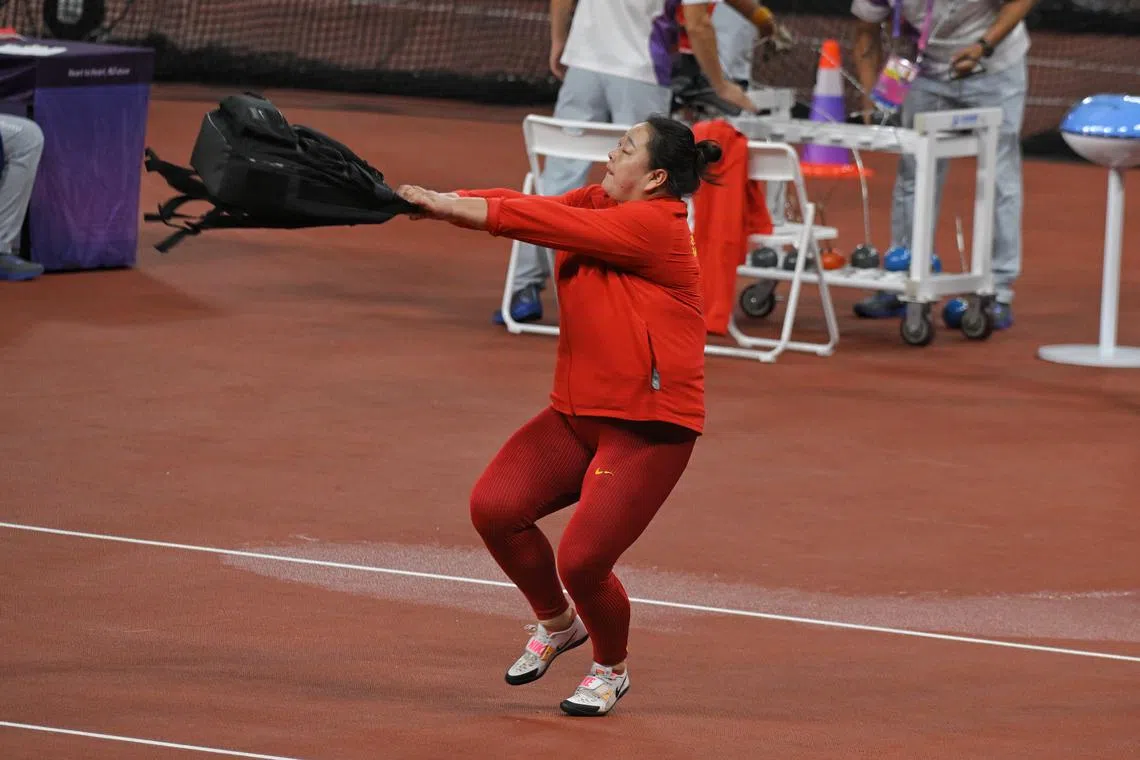 China’s Wang Zheng using her bag to warm up at the 19th Asian Games Women’s Hammer Throw final at the Hangzhou Olympic Sports Centre Stadium on Sept 29.