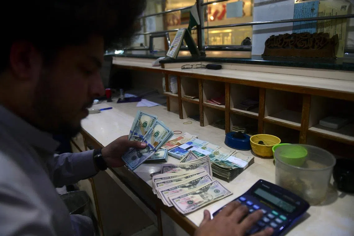 A dealer holds US dollars at a money exchange market in Karachi on Jan 26, 2023.