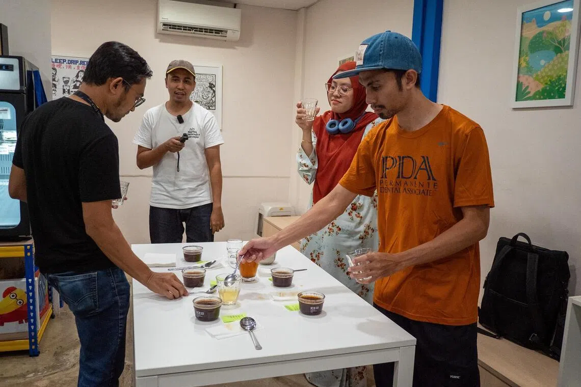 hakopi - Cafe owner Akmal Zamri, second from left, recording a coffee cupping session at Temerloh's Kopi Empat Petang with friends.
ST PHOTO: HADI AZMI