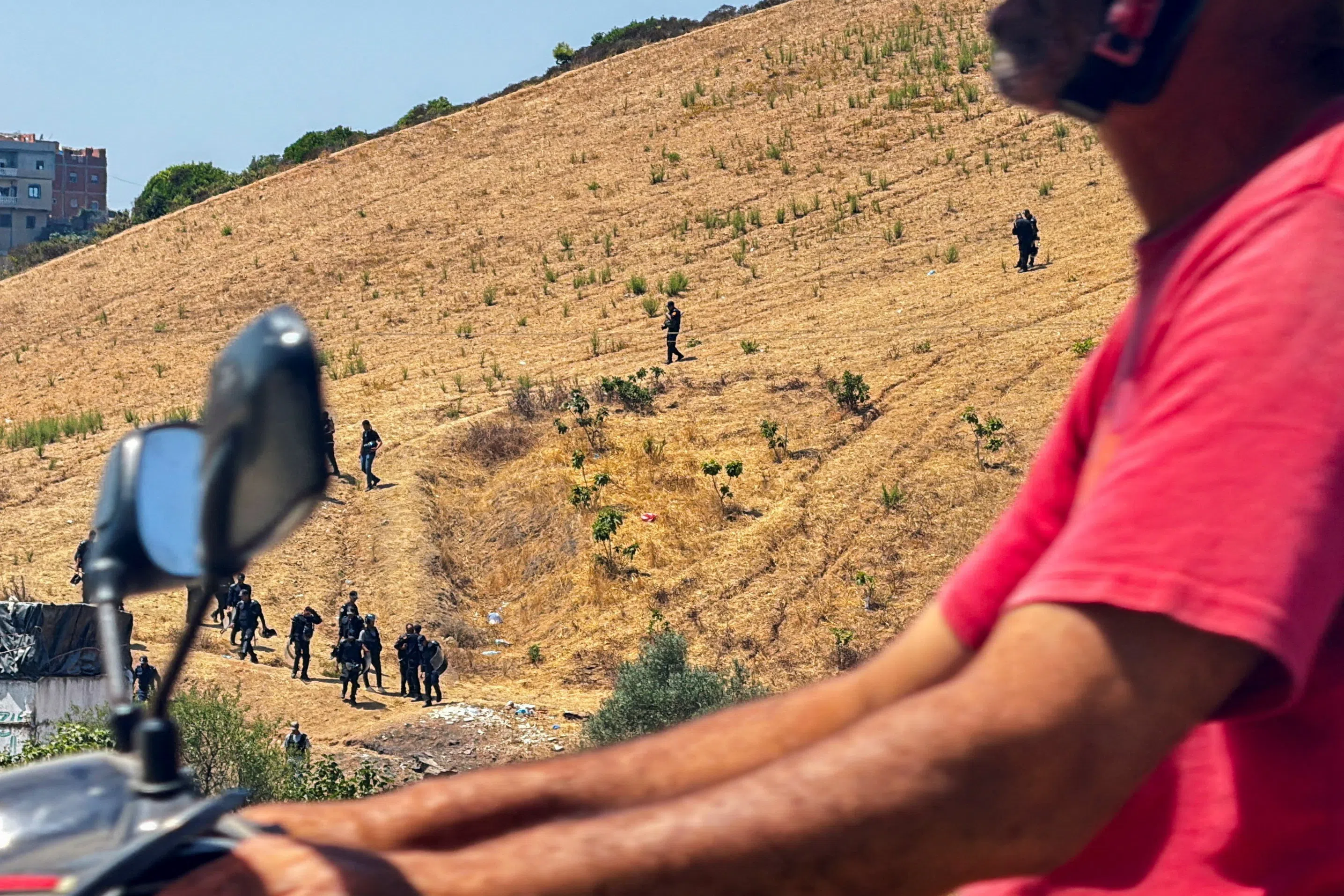Moroccan security personnel searching a hillside in Fnideq, Morocco, on Aug 15, in an effort to locate migrants potentially attempting to cross irregularly into the north African Spanish enclave of Ceuta.