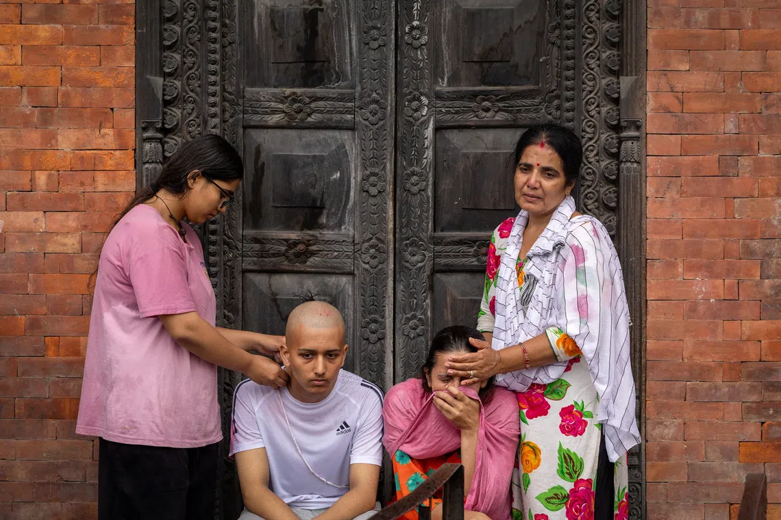 Kamala Bhattarai and Darshan Bhattarai, the wife and son of Pushpa Raj Bhattarai, 46, who died in deadly flash floods and a mudslide, mourn during his cremation ceremony using an effigy because the body remains missing, at Pashupatinath Temple in Kathmandu, Nepal, September 3, 2026. REUTERS/Adnan Abidi TPX IMAGES OF THE DAY