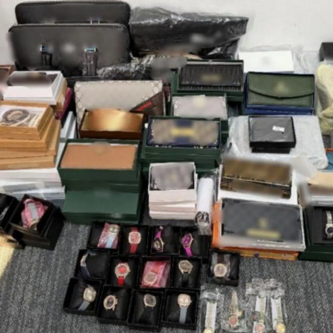 Seized items include luxury bags, wallets, watches, sunglasses, pouches and accessories.