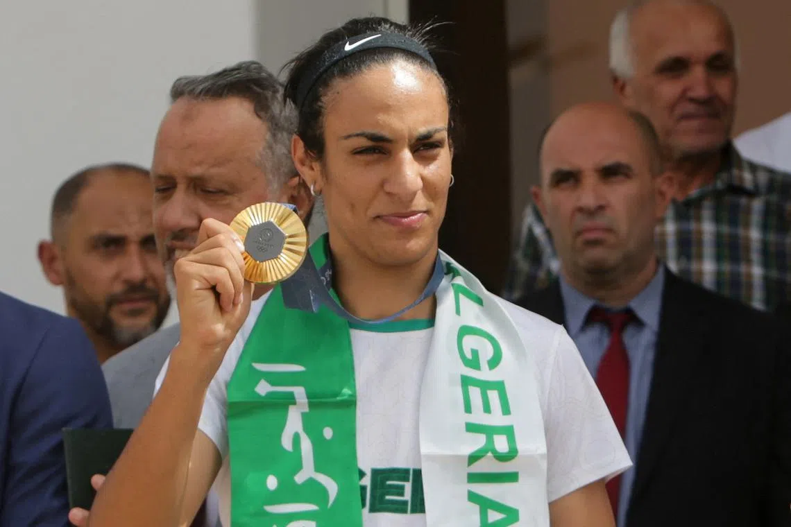 FILE PHOTO: Algerian boxer Imane Khelif, who won the gold medal in the women's welterweight boxing at the Olympics, holds her medal upon her arrival at the airport in Algiers, Algeria  August 12, 2024. REUTERS/Ramzi Boudina/File Photo