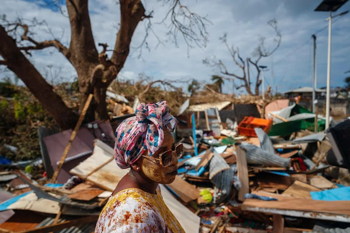 A woman standing in front of her destroyed house in Pamandzi, on the French Indian Ocean territory of Mayotte, on Dec 17, 2024, after the cyclone Chido hit the archipelago. Rescuers raced against time to reach survivors and supply urgent aid after the devastating cyclone Chido ripped through the French Indian Ocean territory of Mayotte, destroying homes across the islands, with hundreds feared dead. 