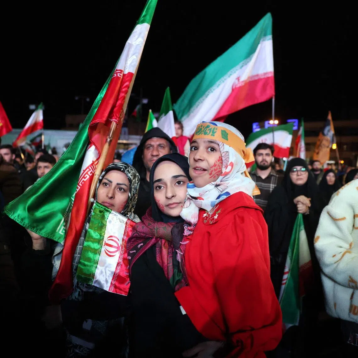 Iranians react with relief after a ceasefire announcement at the Enqelab square, in Tehran.