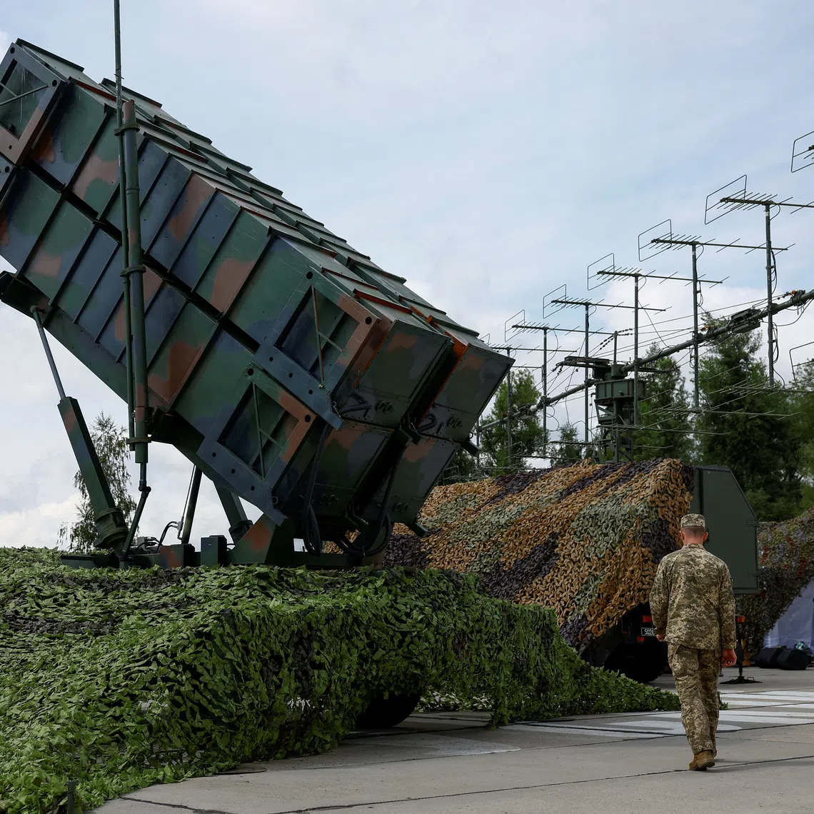 FILE PHOTO: Ukrainian service members walk next to a launcher of a Patriot air defence system, amid Russia's attack on Ukraine, in an undisclosed location, Ukraine August 4, 2024. REUTERS/Valentyn Ogirenko/File Photo