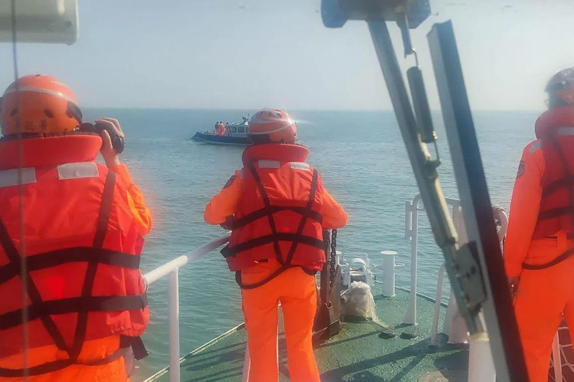 This handout photo taken on Feb 14, 2024 by the Taiwan Coast Guard and released on Feb 15 shows Taiwanese Coast Guard staff surrounding an overturned Chinese speed boat near the Kinmen Islands. 