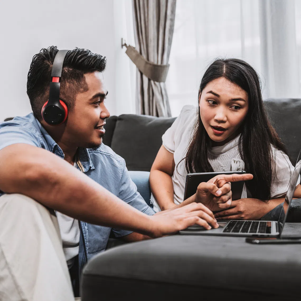 young couple using devices connected seamlessly to internet with singtel wifi 7 best home fibre broadband plan in singapore