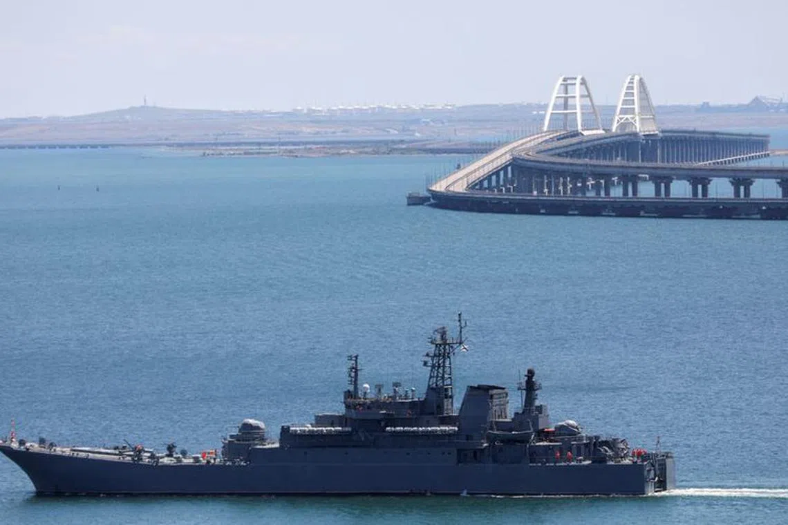 A Russian Navy amphibious landing ship that was deployed to transport cars across the Kerch Strait, moves near the Crimean Bridge, a section of which was damaged by an alleged overnight attack, as seen from the city of Kerch, Crimea, July 17, 2023. REUTERS/Alexey Pavlishak/ File Photo