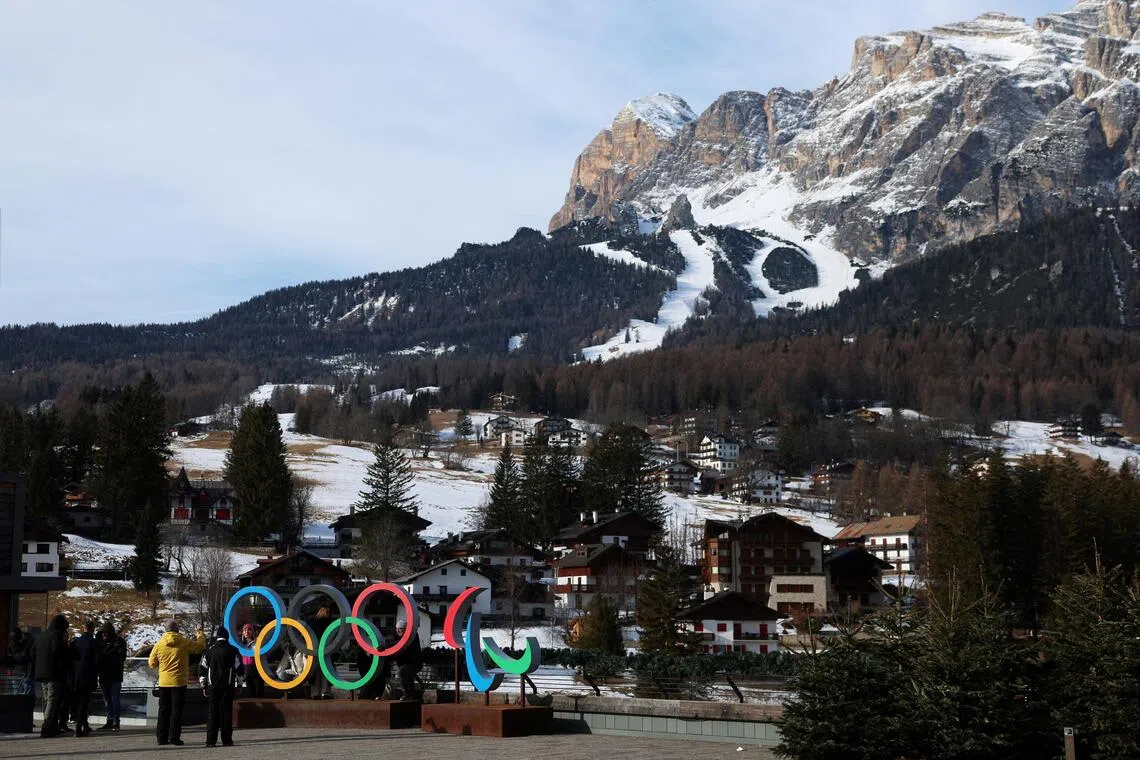 File photo of people posing in front of the Olympic rings and Olympia delle Tofane track, which will host the women's alpine skiing competition of the Milano Cortina Winter Olympic Games in 2026.