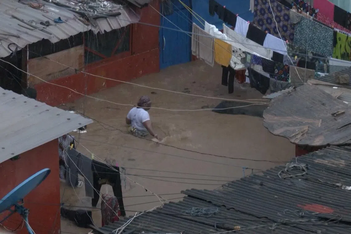 A person wades through floodwaters, in Accra, Ghana, in this still image taken from a video, June 29, 2026. Reuters TV via REUTERS