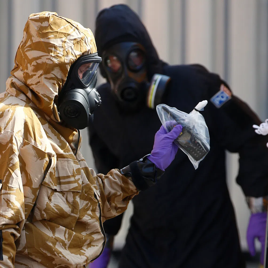 Forensic investigators, wearing protective suits, emerge from the rear of John Baker House, after it was confirmed that two people had been poisoned with the nerve-agent Novichok, in Amesbury, Britain, July 6, 2018. REUTERS/Henry Nicholls