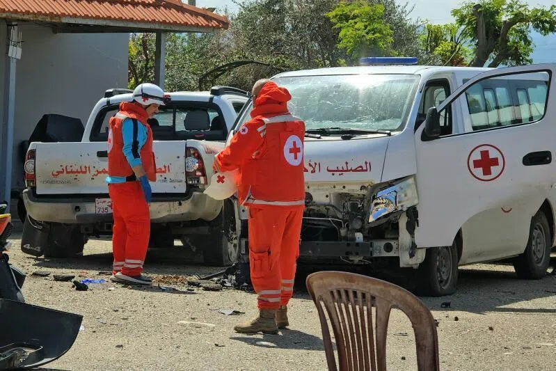Lebanese Red Cross volunteers inspecting the damage to their rescue vehicles at the site of an Israeli drone strike that targeted their headquarters in the southern city of Tyre on April 13.