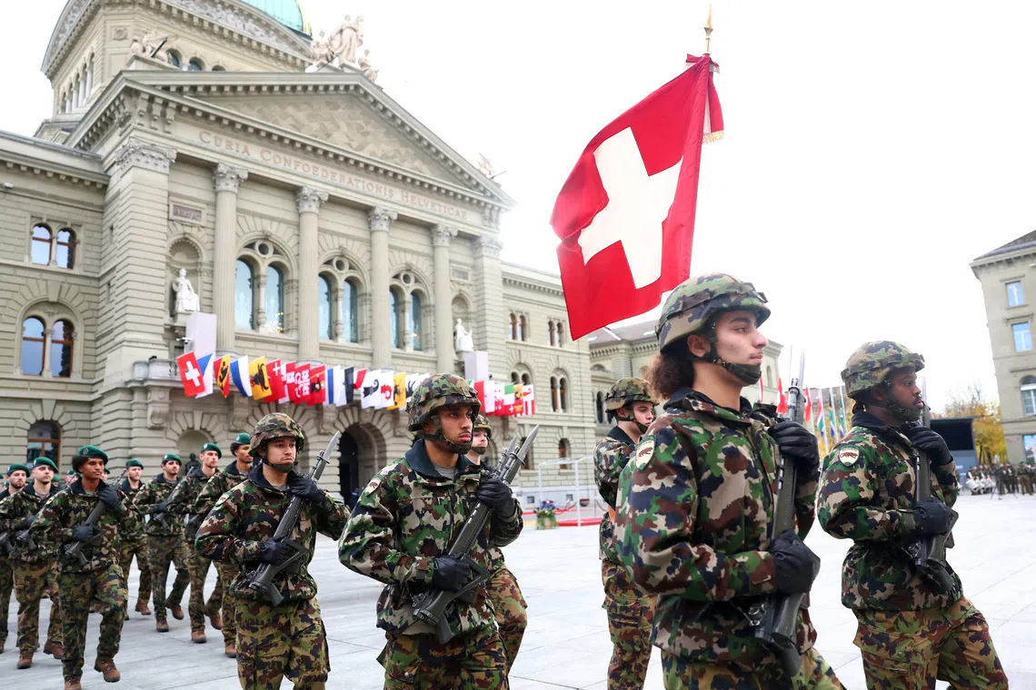 FILE PHOTO: Soldiers from the Swiss army's Infantry Readiness Company 104/1 and the Guard of Honour march past the Swiss Parliament building in Bern, Switzerland, October 29, 2025. REUTERS/Denis Balibouse/File Photo