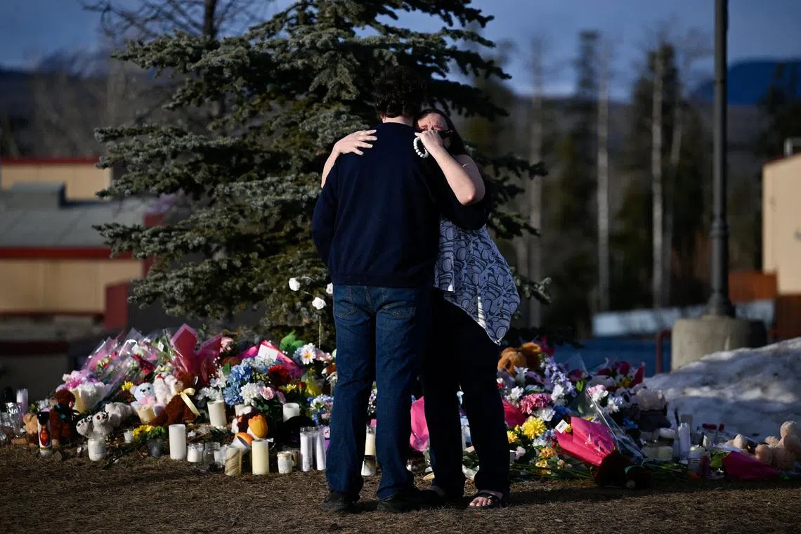 Student Darian Quist and Shelley Quist embrace next to a makeshift memorial for the victims two days after a deadly mass shooting took place at a school, in the town of Tumbler Ridge, British Columbia, Canada February 12, 2026. REUTERS/Jennifer Gauthier     TPX IMAGES OF THE DAY