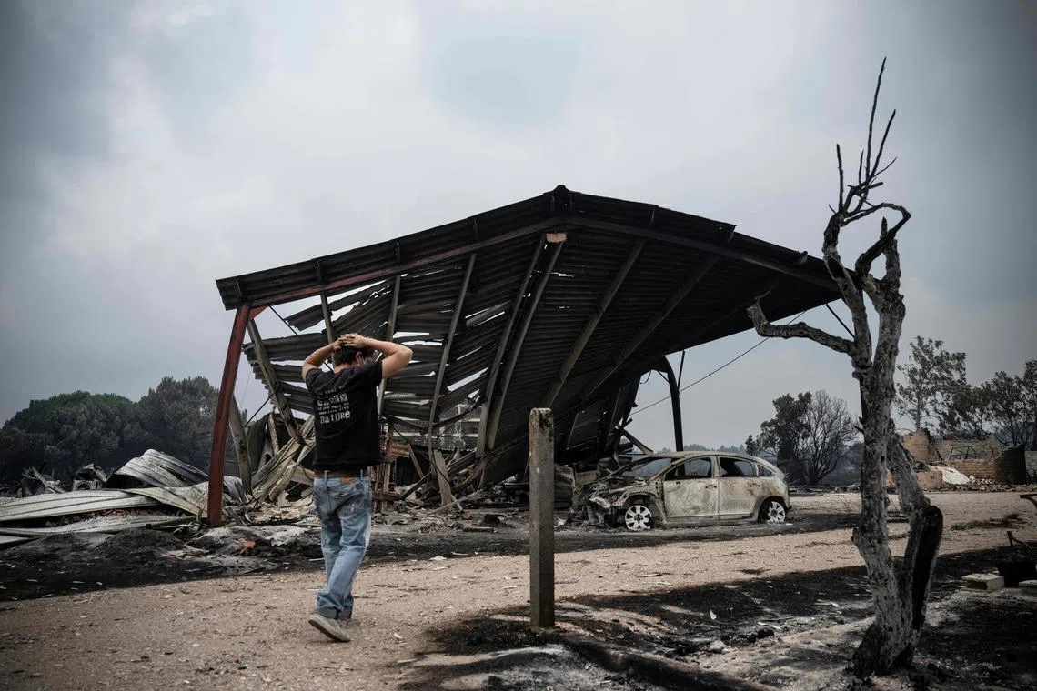 A resident inspects the damage after a wildfire in south-western France on July 25.