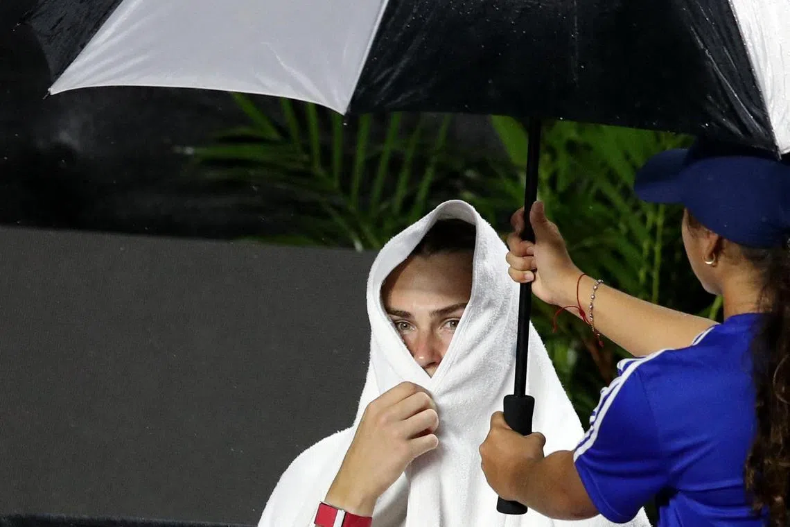 Belarus' Aryna Sabalenka sheltering from the rain as her WTA Finals match against Kazakhstan's Elena Rybakina in Cancun is postponed from Thursday to Friday. The world No. 1 was leading 6-2, 3-5.