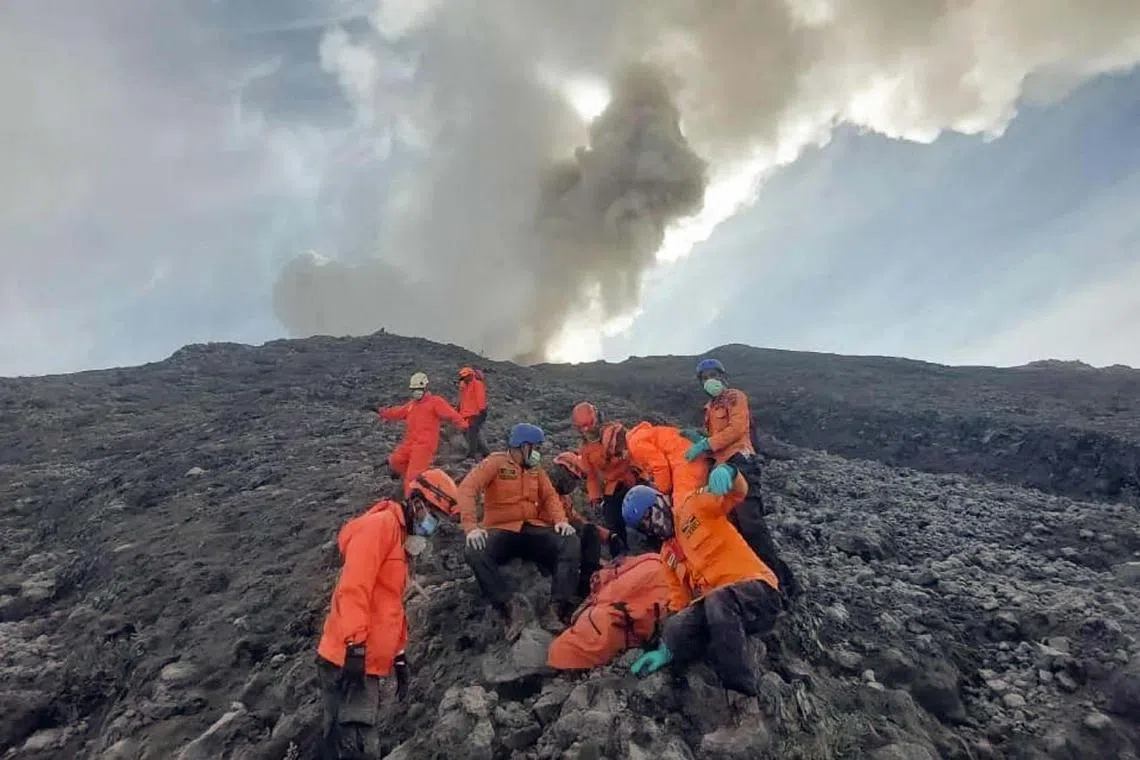 Rescuers evacuating one of the victims from the slopes of Mount Marapi in West Sumatra on Dec 4, 2023. Hundreds of Indonesian rescuers were racing to find hikers who went missing after a volcano eruption killed 13 people.