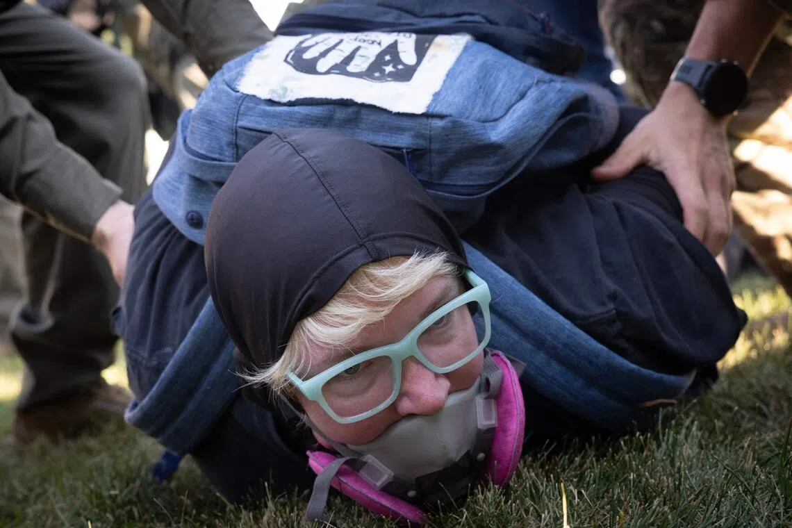 Police taking a demonstrator into custody during a protest outside an immigrant processing and detention centre in Broadview, Illinois, on Oct 3.