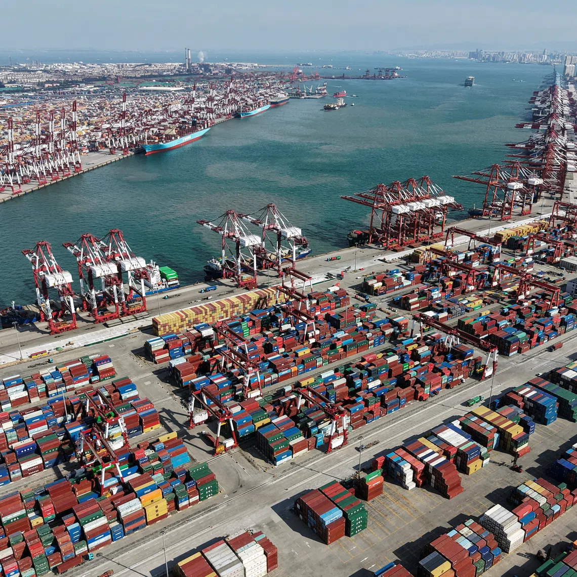 A drone view shows ships and containers at the port in Qingdao, Shandong province, China October 20, 2025. China Daily via REUTERS